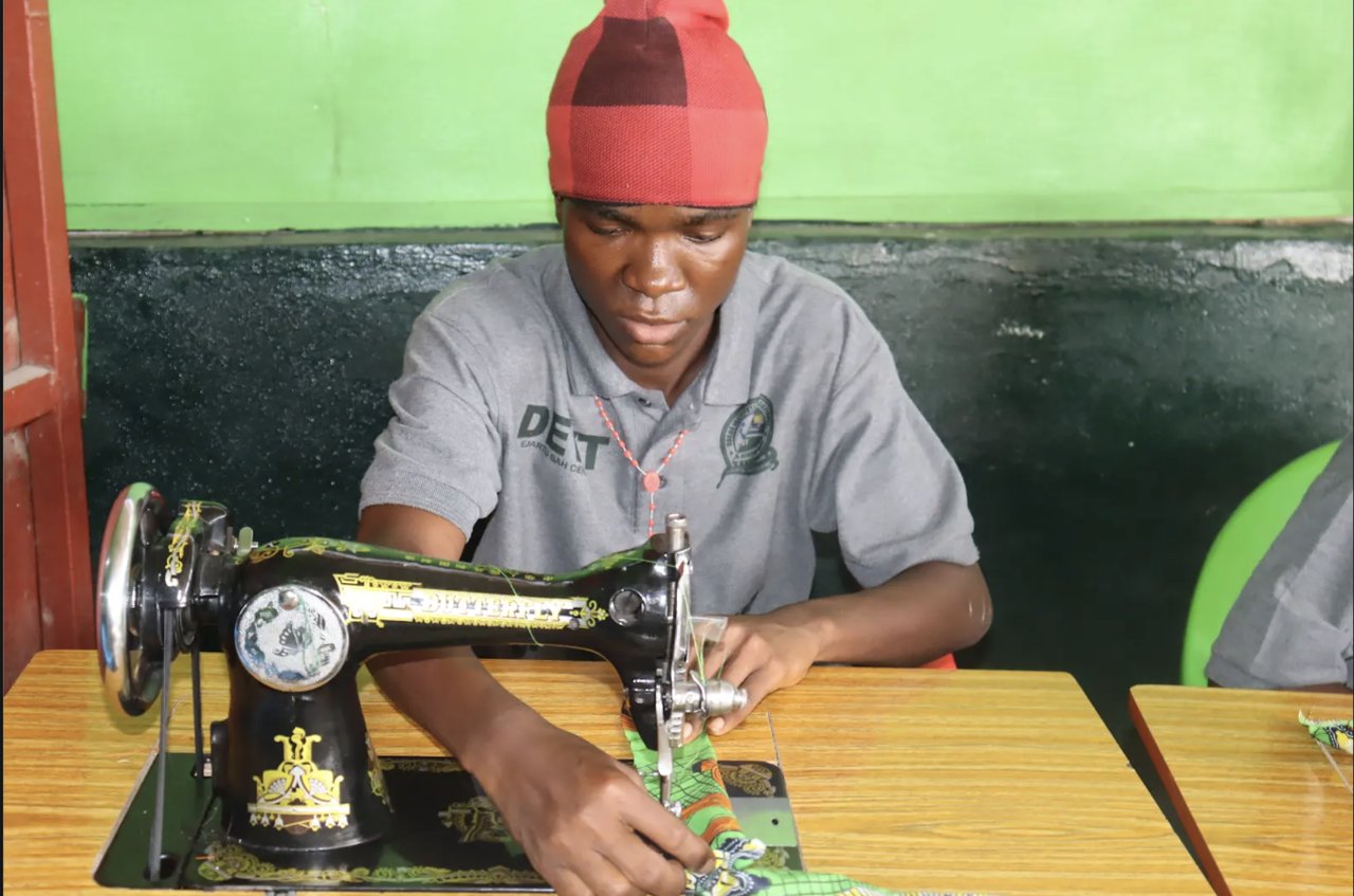 A DEVT Tailoring & Fashion Design student sewing fabric on a manual machine